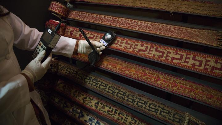 Trabajadora realiza mediciones en colección de trariwe mapuche