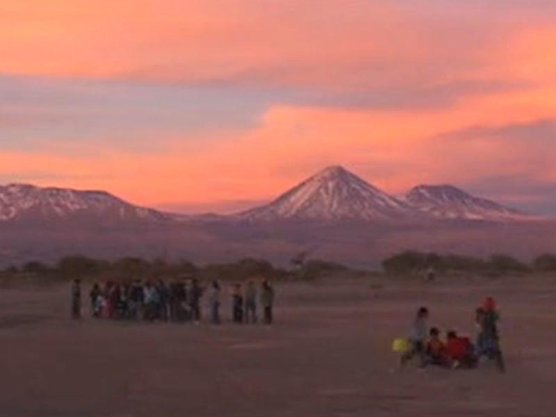 Músicos y bailarines de San Pedro de Atacama, de fondo se ve el volcán Licancabur.